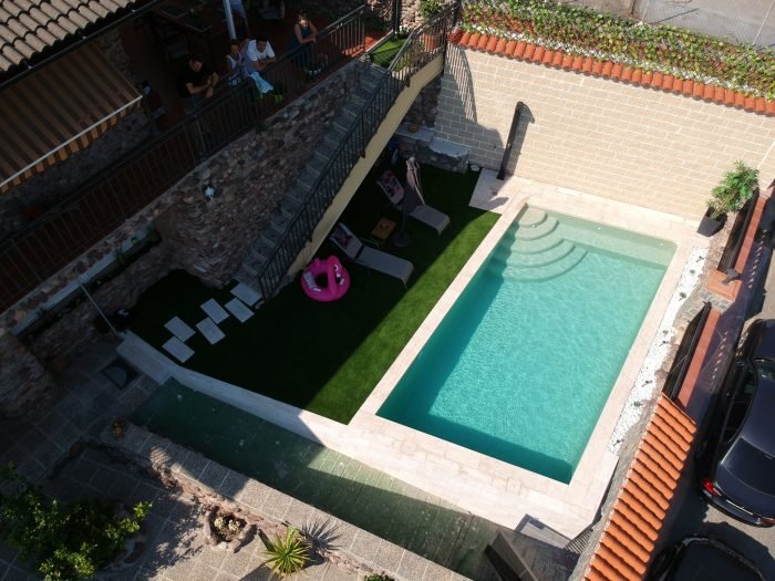 dvorište kuće sa bazenom tirkizne boje vode