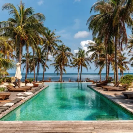 bazen sa svijetlo zelenom bojom vode i mozaik pločicama okružen palmama