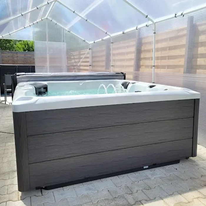 Spa kada Thésée sa tamnom drvenom oblogom ispod providne nadstrešnice